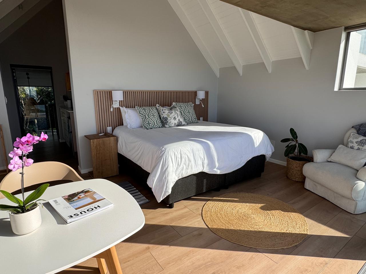 Light-filled bedroom with vaulted ceiling and lounge seating