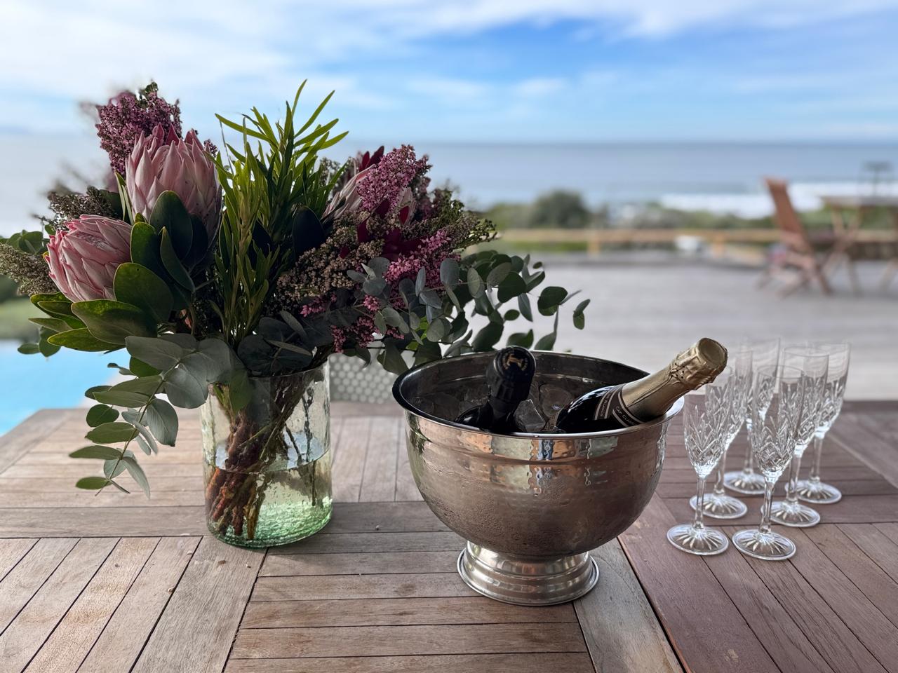 Cap Classique on ice with proteas on the deck, ocean beyond